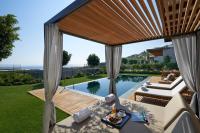a backyard with a swimming pool and a patio with a table at Mandarin Oriental, Bodrum in Golturkbuku