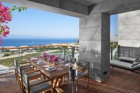 a dining table on a deck with a view of the ocean at Mandarin Oriental, Bodrum in Golturkbuku