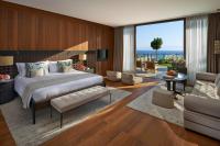 a bedroom with a large bed and a living room at Mandarin Oriental, Bodrum in Golturkbuku