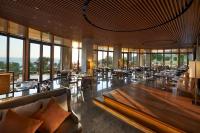 a restaurant with tables and chairs and windows at Mandarin Oriental, Bodrum in Golturkbuku