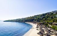 a beach with umbrellas and chairs and the ocean at Mandarin Oriental, Bodrum in Golturkbuku