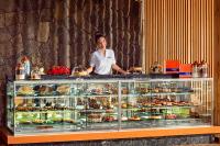a woman standing behind a display case of pastries at Mandarin Oriental, Bodrum in Golturkbuku