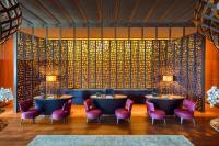 a restaurant with two round tables and pink chairs at Mandarin Oriental, Bodrum in Golturkbuku