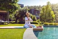 a woman sitting on a surfboard next to a pool at Mandarin Oriental, Bodrum in Golturkbuku