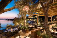 a restaurant with tables and chairs and a view of the water at Mandarin Oriental, Bodrum in Golturkbuku