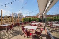 an outdoor patio with tables and chairs and lights at Holiday Inn York by IHG in York