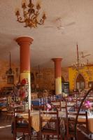 Un comedor con mesas y sillas y una lámpara de araña. en Nubiano Cataract, en Shellal