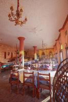 Un comedor con mesas y sillas y una lámpara de araña. en Nubiano Cataract, en Shellal