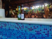 twee flessen bier die op de rand van een zwembad staan bij Hotel Bambus in Felipe Carrillo Puerto