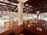 een grote kamer met een houten tafel in een gebouw bij Lavilla Lake Resort And Restaurant in Kollam