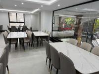 une salle à manger avec des tables et des chaises blanches dans l'établissement Bảo Ngọc Diamond Hotel 2, à Cao Bằng