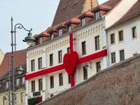 un edificio con un corazón rojo a un lado. en ART Hotel, en Sibiu