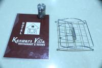 a book and a sign with a bird cage on a table at Kanwar Villa Bir in Chauntrā