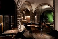 a restaurant with tables and chairs and a brick wall at San Anton Hotel in Trecastagni