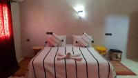 Un dormitorio con una cama rosa con un arco rosa. en Hôtel Restaurant Dar Al Madina, en Tinerhir