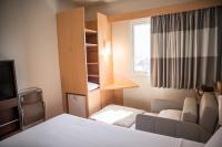 a hotel room with a bed and a couch and a window at ibis Itu Plaza Shopping in Itu