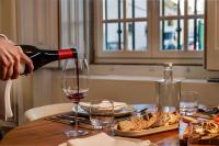 une personne versant du vin dans un verre sur une table dans l'établissement CICIOSO boutique hotel, à Évora