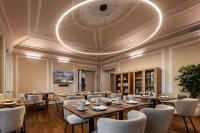 un restaurant avec des tables en bois et des chaises blanches dans l'établissement CICIOSO boutique hotel, à Évora