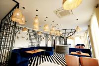 un ristorante con sedie blu, tavoli e lampadari a braccio di Hari Mahal Resort a Behror