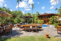 a patio with tables and chairs next to a pool at Tambor Tropical Beach Resort- Adults Only in Tambor