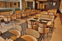 a restaurant with tables and chairs in a room at Royal Ritis in Belgaum