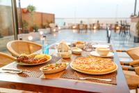 a table with two pizzas and plates of food on it at Sultan Pyramids Boutique Hotel View in ‘Ezbet `Abd el-Ḥamîd