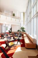 Una sala de espera con mesas y sillas en un edificio. en The Durham Hotel, en Durham