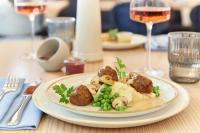 um prato de comida com cogumelos e ervilhas sobre uma mesa em Novotel Hamburg Central Station em Hamburgo