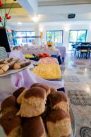 a table topped with different types of bread and cheese at Hotel Sierralago in Villa Carlos Paz