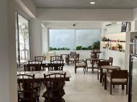 a restaurant with tables and chairs and a large window at VELA Korat Hotel & Cafe' in Nakhon Ratchasima