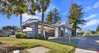 Un edificio con palmeras frente a una calle. en SureStay Plus Hotel by Best Western Sacramento North, en Sacramento