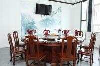 a dining room table with chairs and a tv on a wall at Yue Lai Hotel in Suva