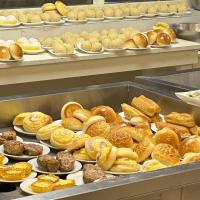 a bunch of different types of donuts and pastries on plates at Yue Lai Hotel in Suva