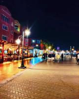 Eine Gruppe von Menschen, die nachts auf einer Straße spazieren in der Unterkunft comfort marina 5 apartment,s in Hurghada
