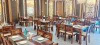 an empty restaurant with wooden tables and chairs at The Byke Boutique - Amra Oasis Osian in Osiān