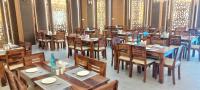 an empty restaurant with wooden tables and chairs at The Byke Boutique - Amra Oasis Osian in Osiān