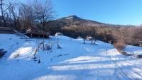 a snow covered field with a mountain in the background at Yourtes Olachat proche Annecy in Faverges