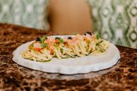 un piatto di pasta con gamberetti e verdure su un tavolo di Palazzo Presta a Gallipoli