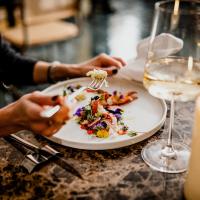 una persona che mangia un piatto di cibo su un tavolo di Palazzo Presta a Gallipoli