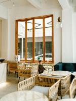 a child sitting in a room with tables and chairs at Guizhou Kaili Leli Designer Hotel in Bainiu