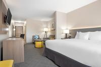 Una habitación de hotel con una cama grande y un escritorio. en Comfort Inn &amp; Suites, en Slidell