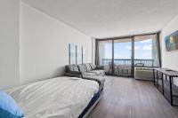 ein Schlafzimmer mit einem Bett und einem Sofa sowie einem Balkon in der Unterkunft Compass Cove 759 - Oceanfront in Myrtle Beach
