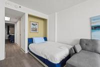 Bett in einem Zimmer mit Sofa und Stuhl in der Unterkunft Compass Cove 759 - Oceanfront in Myrtle Beach