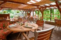 ein Restaurant mit Tischen und Stühlen und einer Pergola in der Unterkunft Logis Hotel Restaurant Le Faudé in Lapoutroie