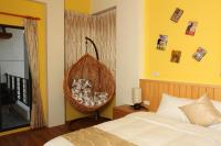 a bedroom with a bed and a wicker chair at CarNo B&amp;B in Yuanshan