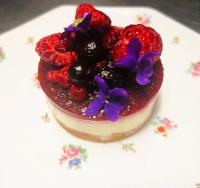 ein Dessert mit Beeren und Blüten auf einem Teller in der Unterkunft Les Tuileries de Chanteloup in La Roche-Chalais