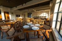 Un restaurante vacío con mesas y sillas de madera. en SinQ Anvaya, en Maem