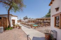 a resort with a swimming pool and a building at Hotel La Cochera in San Pedro de Atacama