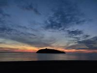 an island in the middle of the ocean at sunset at a due passi dal mare in Diamante
