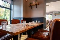 a large wooden table in a restaurant with chairs at Cardross Inn in Cardross